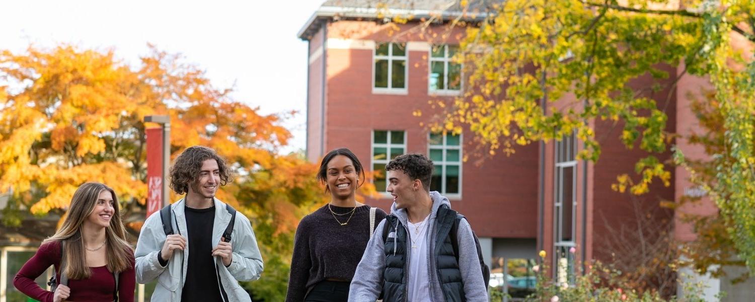 四名SPU学生, 三个男学生和一个女学生, 走在校园里，背景是伊顿科学楼.